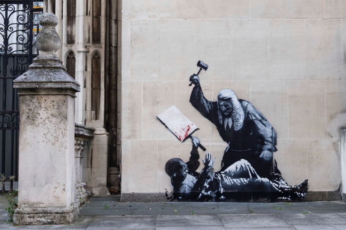 Σάλος με το νέο έργο του Banksy: Δικαστής ξυλοκοπεί διαδηλωτή ‑ Κάλυψαν άρον άρον το γκράφιτι
