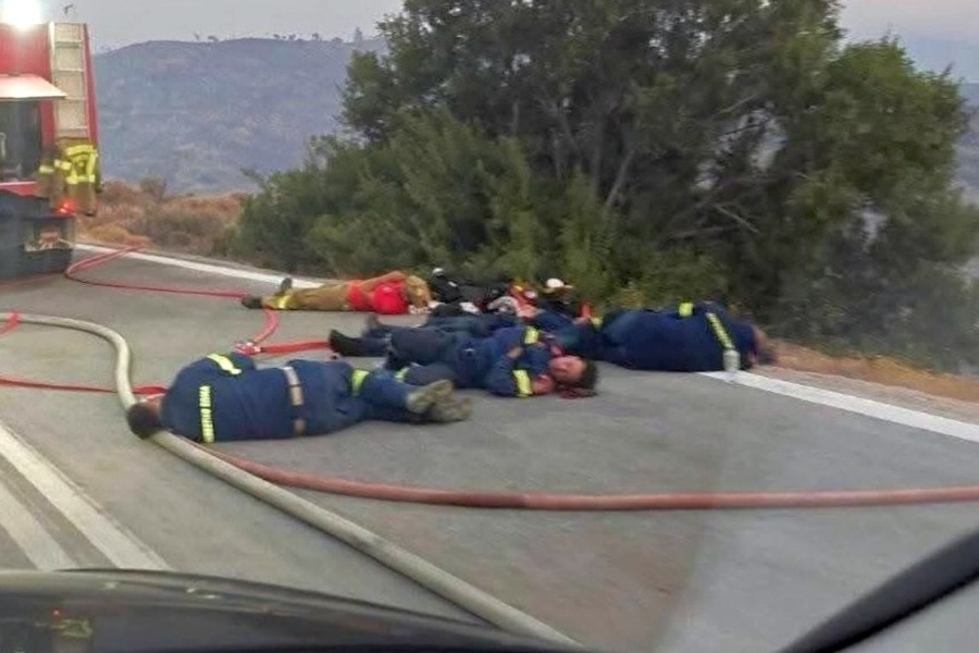 Εξαντλημένοι πυροσβέστες ξαπλώνουν στη μέση του δρόμου